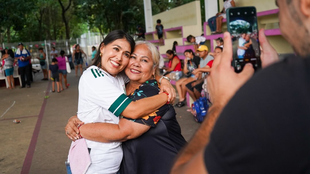 Mirella y una vecina se abrazan sonriendo en una jornada de Club Corazón