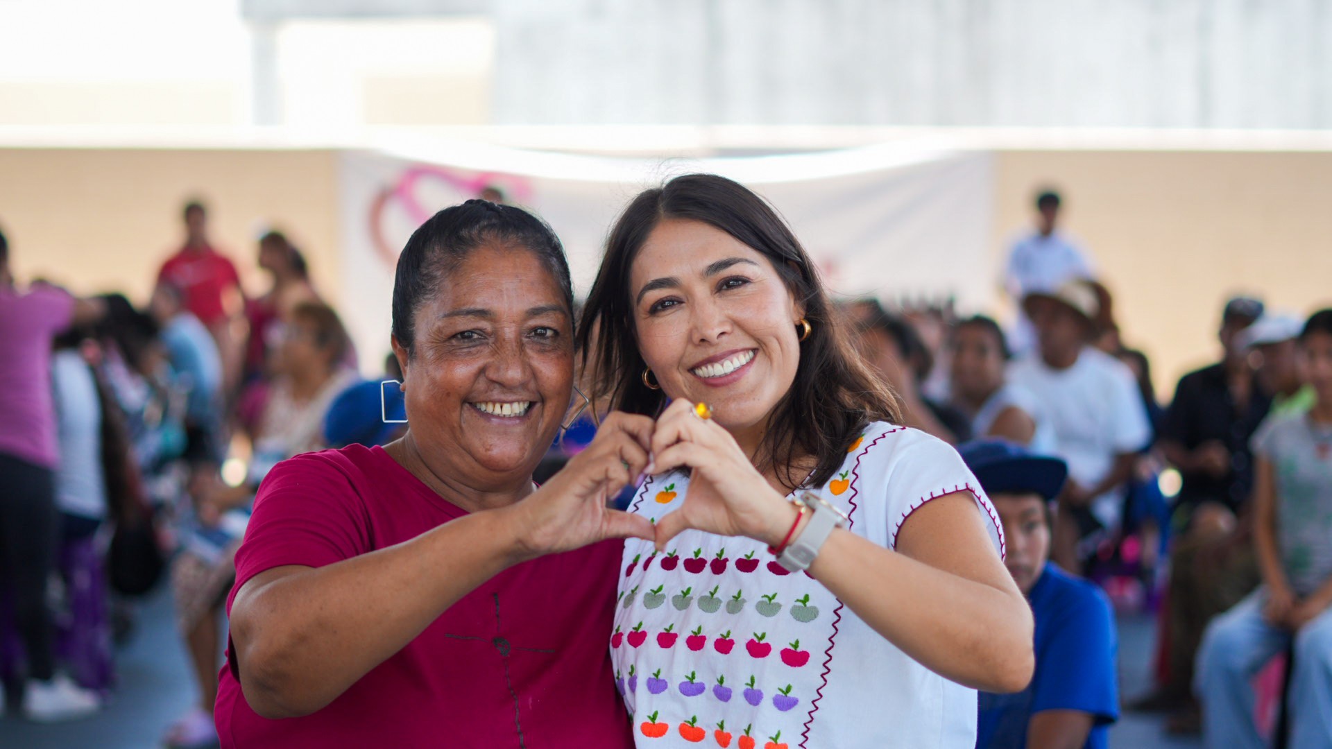 Mirella y una vecina forman un corazón con las manos en una jornada de Club Corazón