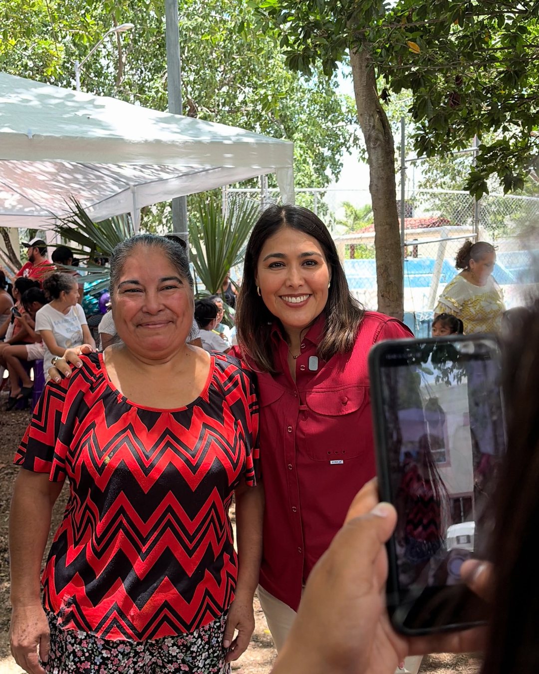 Mirella Díaz sonríe junto a una vecina que se toma foto con ella en una jornada de Club Corazón